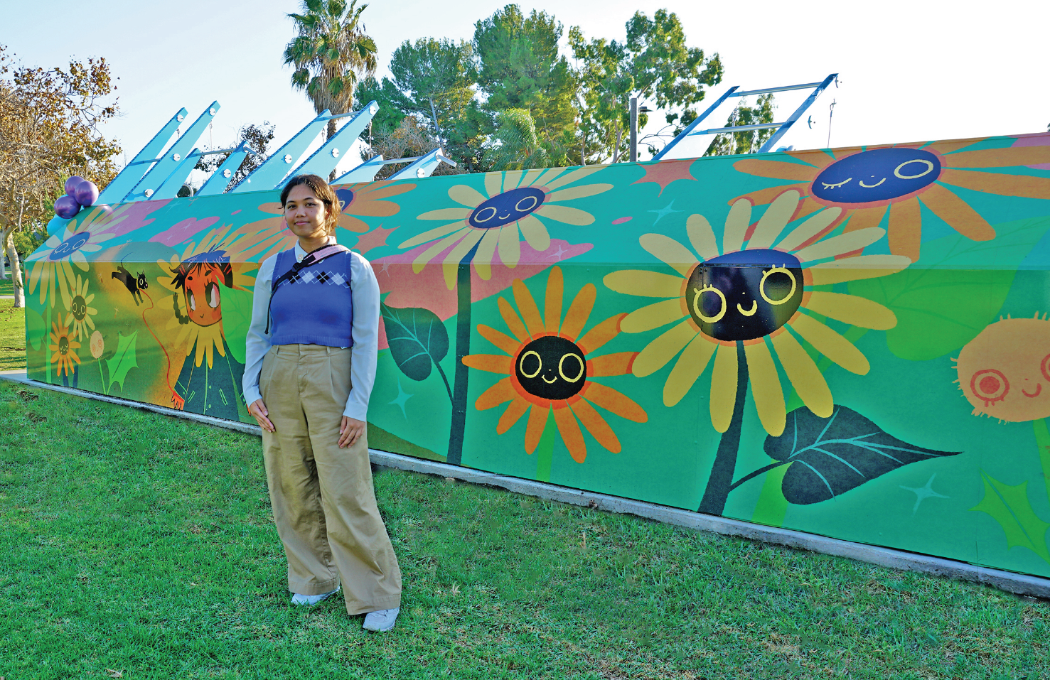 artist in front of their work on the Fitness Court